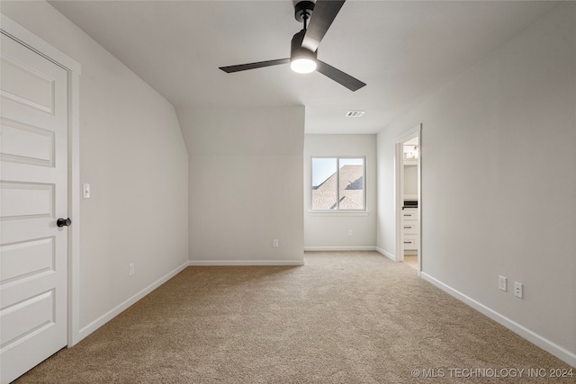 interior space with lofted ceiling, light colored carpet, and ceiling fan