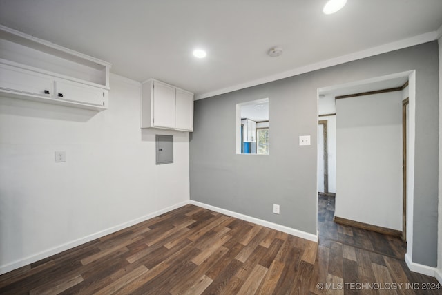 laundry area with crown molding, electric panel, and dark hardwood / wood-style flooring