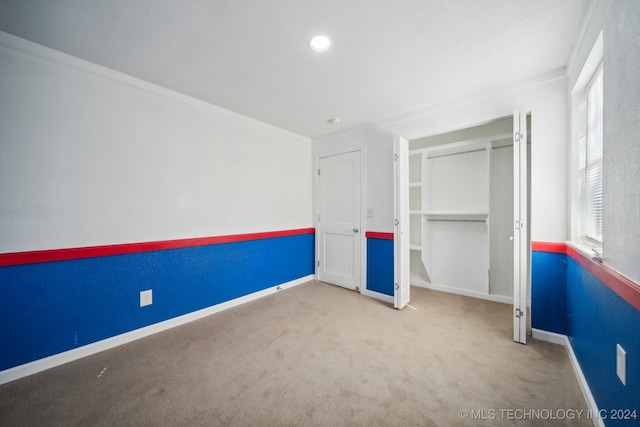 unfurnished bedroom featuring carpet and crown molding