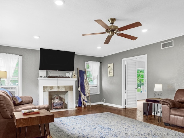 living room featuring ornamental molding, dark hardwood / wood-style floors, plenty of natural light, and ceiling fan