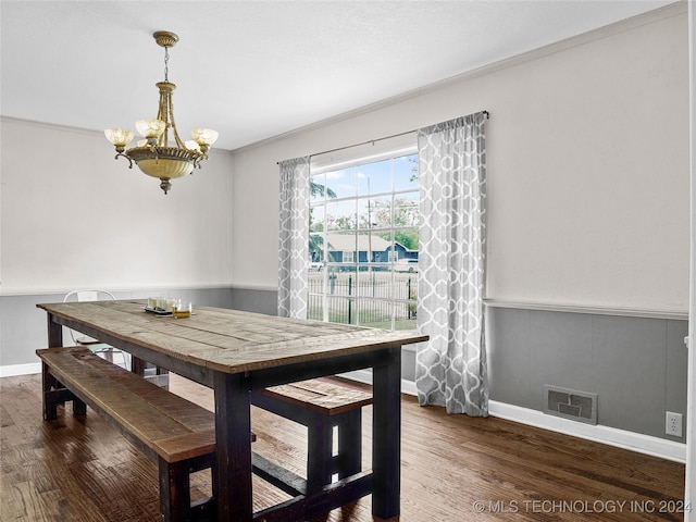 dining room with crown molding, a notable chandelier, and dark hardwood / wood-style floors