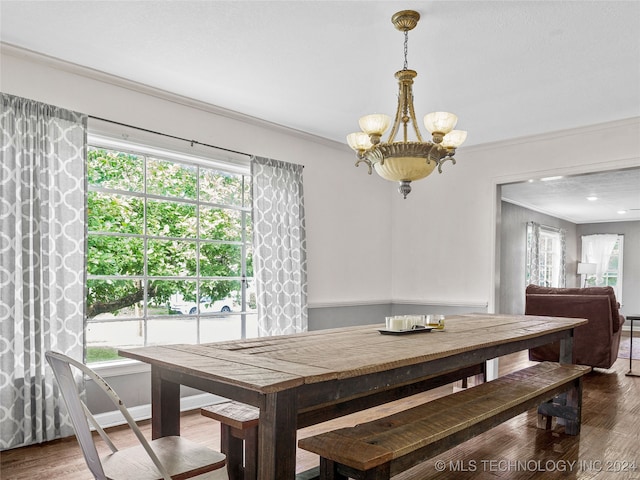 dining room featuring an inviting chandelier, hardwood / wood-style flooring, and crown molding