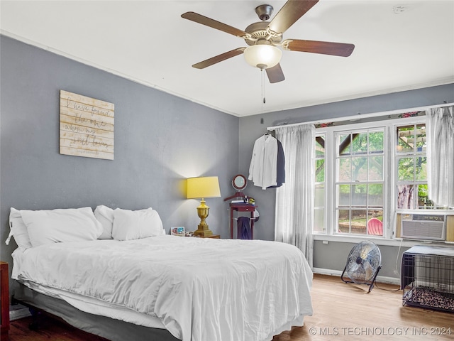 bedroom with ceiling fan, cooling unit, and light hardwood / wood-style floors