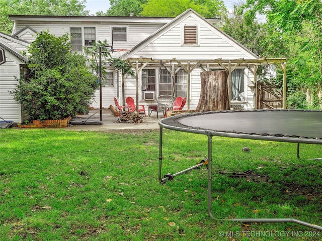 back of property with a patio, cooling unit, a trampoline, and a lawn