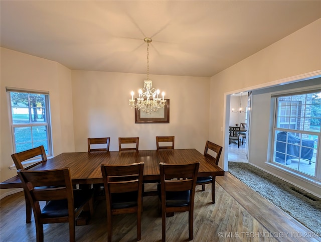 dining space with an inviting chandelier and hardwood / wood-style flooring