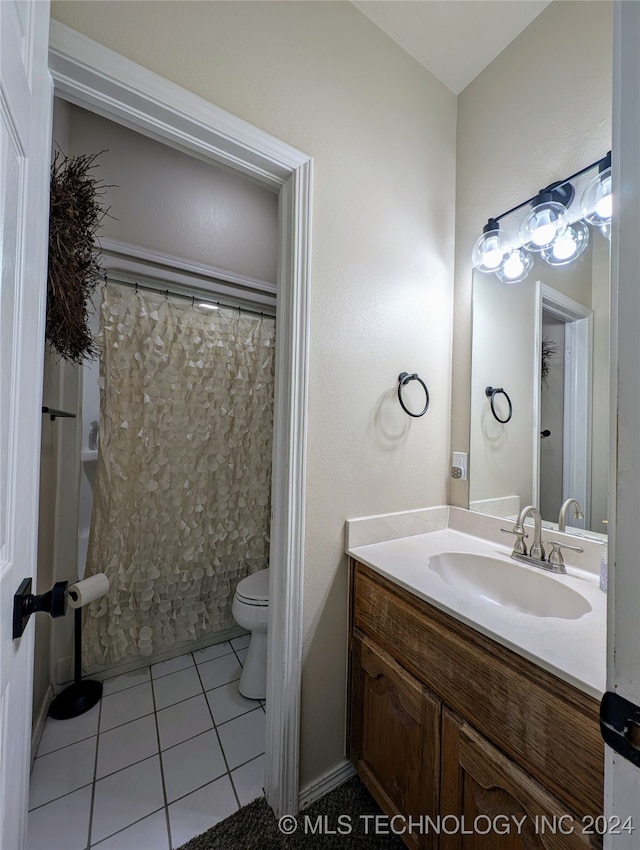 bathroom featuring toilet, a shower with curtain, vanity, and tile patterned floors