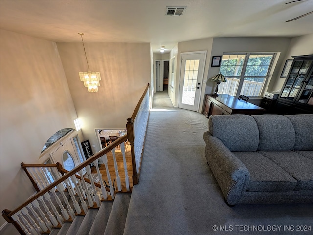 stairway featuring a chandelier and carpet