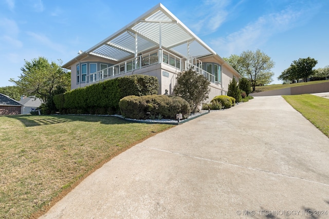 view of home's exterior featuring a lawn and a balcony