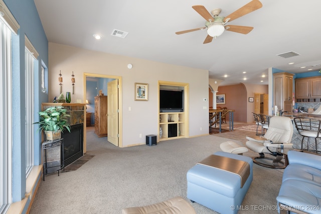 carpeted living room with ceiling fan