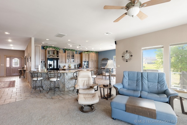 living room featuring light colored carpet and ceiling fan