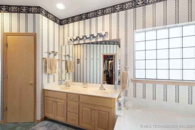 bathroom featuring a washtub, vanity, and plenty of natural light