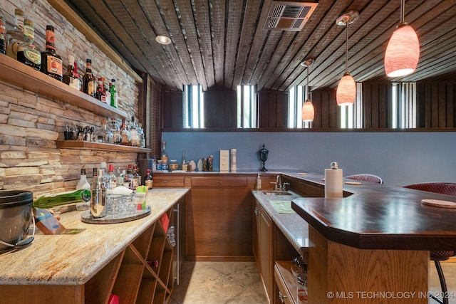 bar featuring wood ceiling, light stone counters, hanging light fixtures, and a wealth of natural light