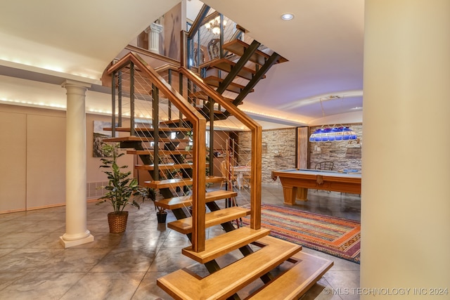 staircase with decorative columns and pool table