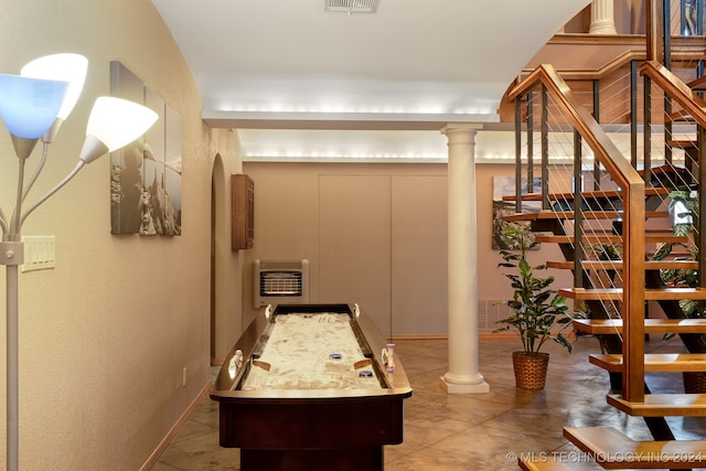 interior space with tile patterned floors, ornate columns, and heating unit