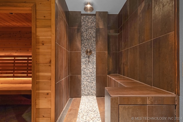 bathroom with wood walls and tile patterned floors