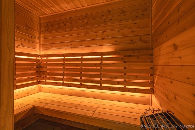 view of sauna featuring wooden ceiling and wood walls