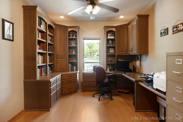 office area with built in desk, ceiling fan, and light hardwood / wood-style flooring