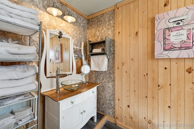 bathroom with vanity and wood walls