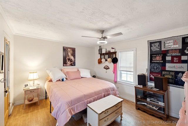 bedroom featuring ornamental molding, a textured ceiling, light wood-type flooring, and ceiling fan