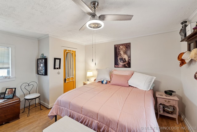 bedroom featuring light hardwood / wood-style floors, ornamental molding, a textured ceiling, and ceiling fan