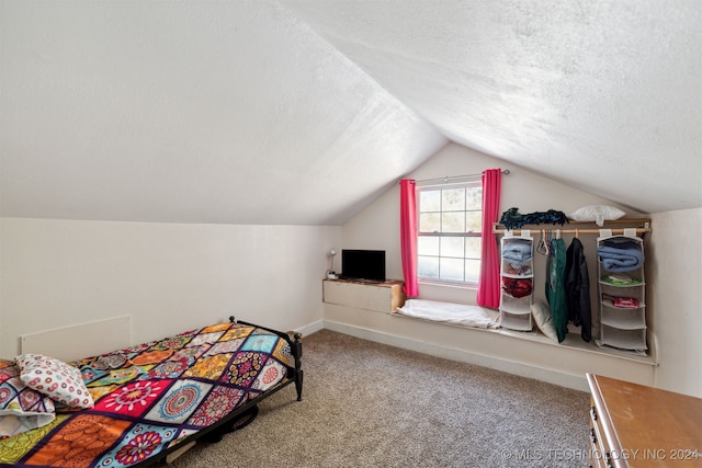 carpeted bedroom featuring a textured ceiling and lofted ceiling