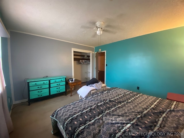 bedroom featuring crown molding, ceiling fan, a textured ceiling, carpet floors, and a closet