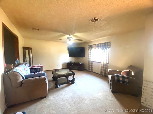 living room with ceiling fan, light colored carpet, and a textured ceiling