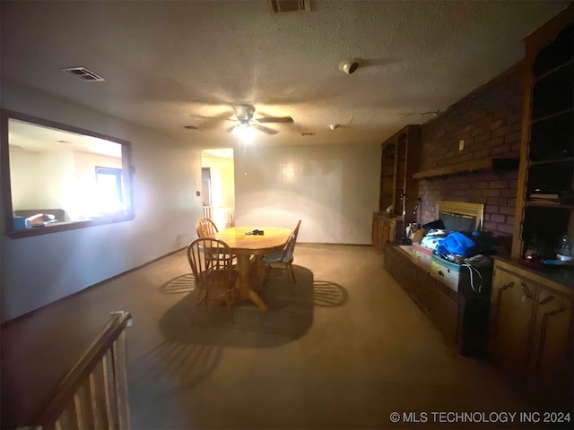 dining space featuring a fireplace, a textured ceiling, light colored carpet, and ceiling fan