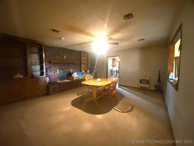 carpeted dining room with a fireplace, a textured ceiling, heating unit, and ceiling fan