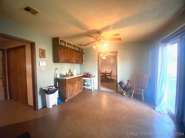 kitchen with ceiling fan and a textured ceiling