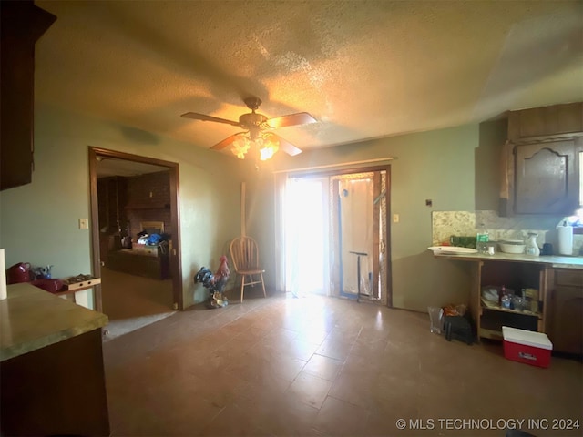 miscellaneous room featuring ceiling fan and a textured ceiling