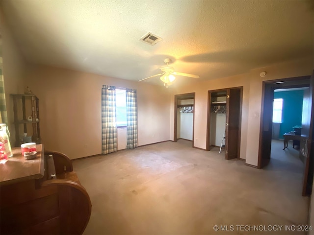 bedroom with light carpet, a textured ceiling, and ceiling fan