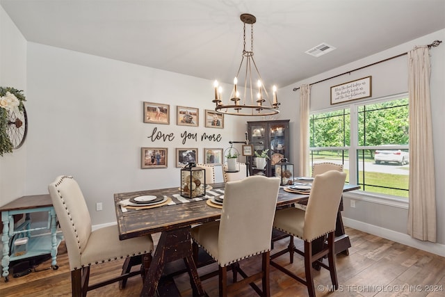 dining area with a notable chandelier and dark hardwood / wood-style floors