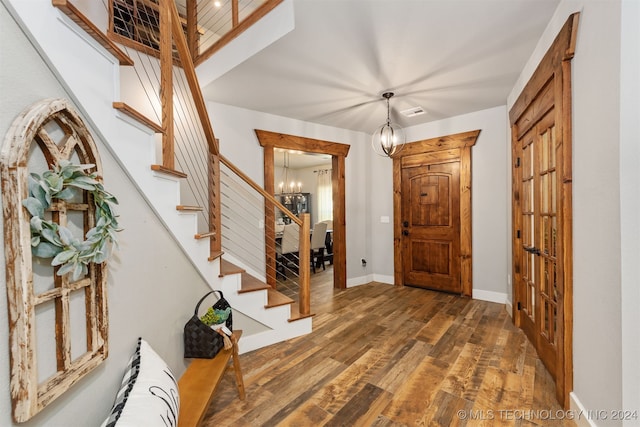 foyer entrance with a chandelier and dark hardwood / wood-style floors