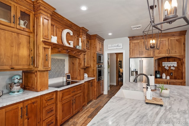 kitchen with tasteful backsplash, hardwood / wood-style flooring, stainless steel appliances, sink, and decorative light fixtures