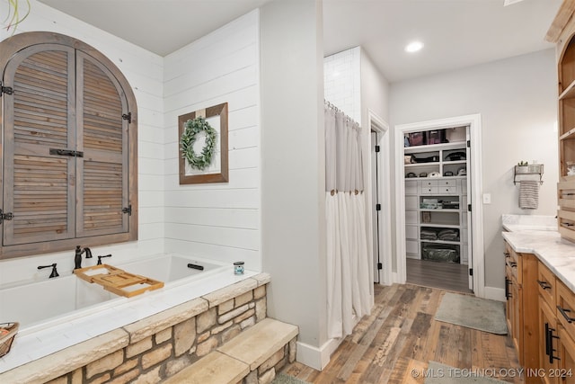 bathroom featuring vanity, wood-type flooring, and a tub