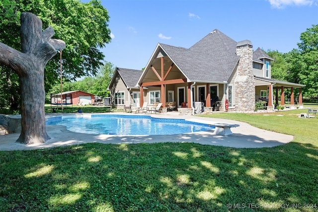 view of swimming pool with a diving board, a patio area, and a lawn