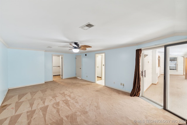 unfurnished bedroom featuring light carpet, ceiling fan, vaulted ceiling, ornamental molding, and a closet