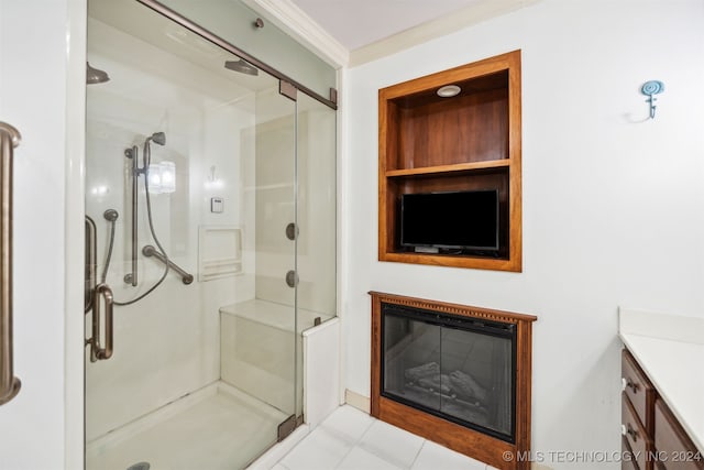 bathroom featuring a shower with door, vanity, crown molding, and tile patterned flooring