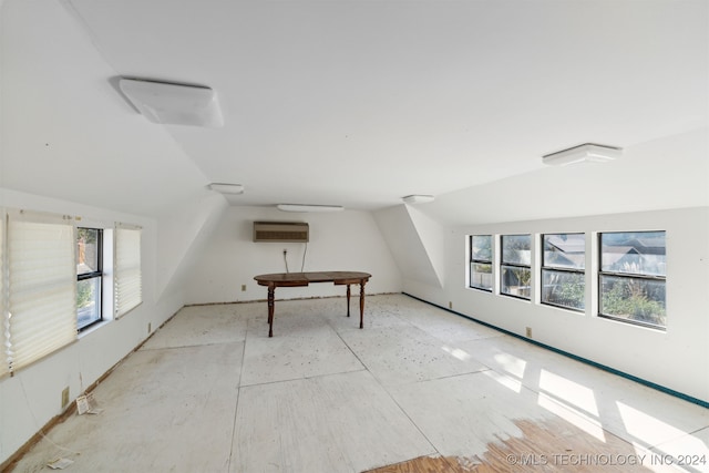 bonus room with lofted ceiling, a wealth of natural light, and a wall mounted air conditioner