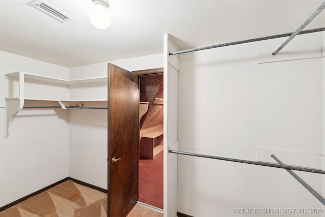 spacious closet featuring light carpet