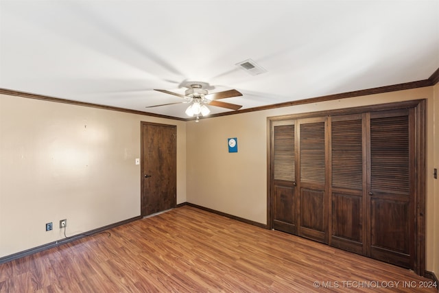 unfurnished bedroom featuring crown molding, light wood-type flooring, and ceiling fan