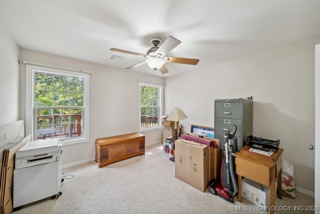 office space featuring ceiling fan, a wealth of natural light, and light colored carpet