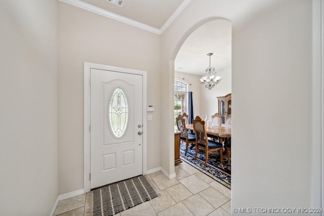 entryway featuring crown molding, a chandelier, and light tile patterned flooring