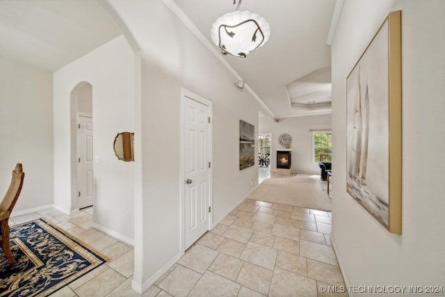 hall with ornamental molding and light tile patterned flooring