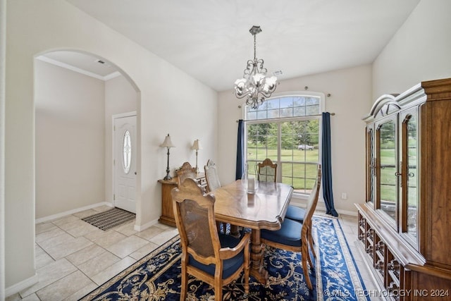 tiled dining area featuring ornamental molding and an inviting chandelier