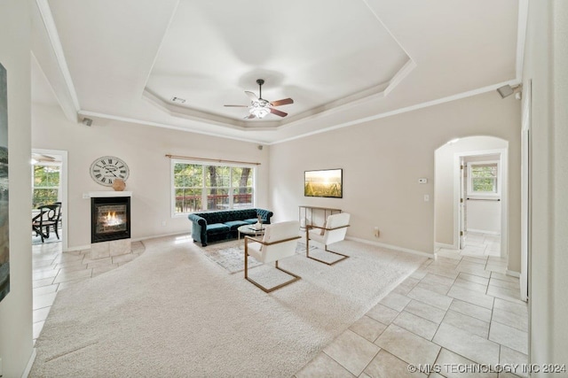 living room featuring light tile patterned floors, a raised ceiling, and ceiling fan