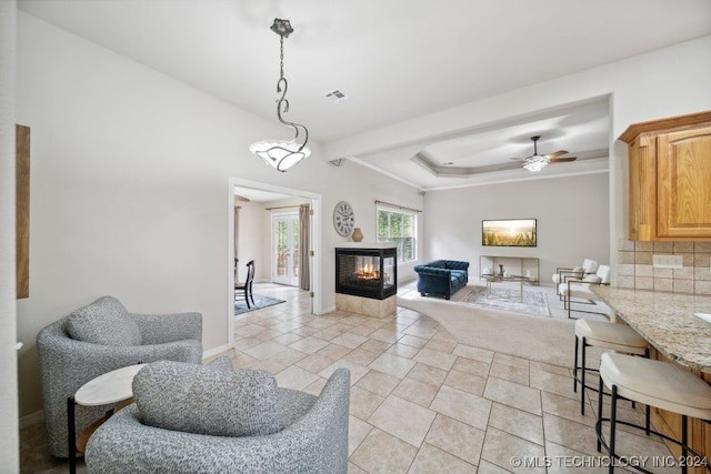 living room featuring a multi sided fireplace, light tile patterned floors, and ceiling fan