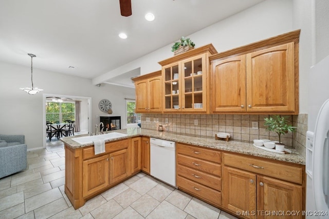 kitchen featuring white appliances, sink, kitchen peninsula, pendant lighting, and decorative backsplash