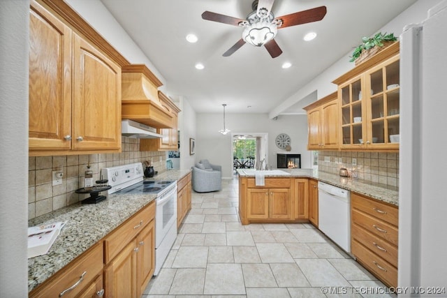 kitchen with decorative backsplash, hanging light fixtures, kitchen peninsula, ventilation hood, and white appliances